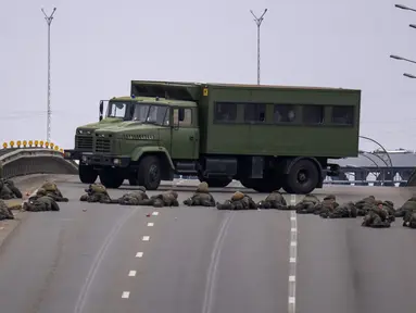 Tentara Ukraina mengambil posisi di sebuah jembatan di dalam Kota Kiev, Ukraina, Jumat (25/2/2022). Rusia menekan invasinya sampai ke pinggiran Kiev setelah melepaskan serangan udara di kota-kota dan pangkalan militer serta mengirimkan pasukan dan tank dari tiga sisi. (AP Photo/Emilio Morenatti)