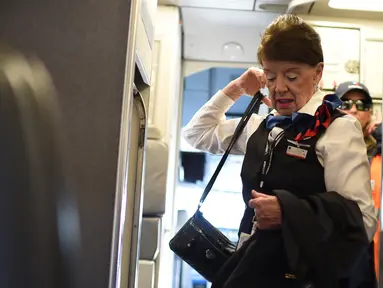 Pramugari tertua di maskapai American Airlines, Bette Nash membawa barang-barangnya sebelum melakukan penerbangan ke Boston di Bandara Ronald Reagan Washington di Arlington, Virginia (19/21). (AFP Photo/Eric Baradat)