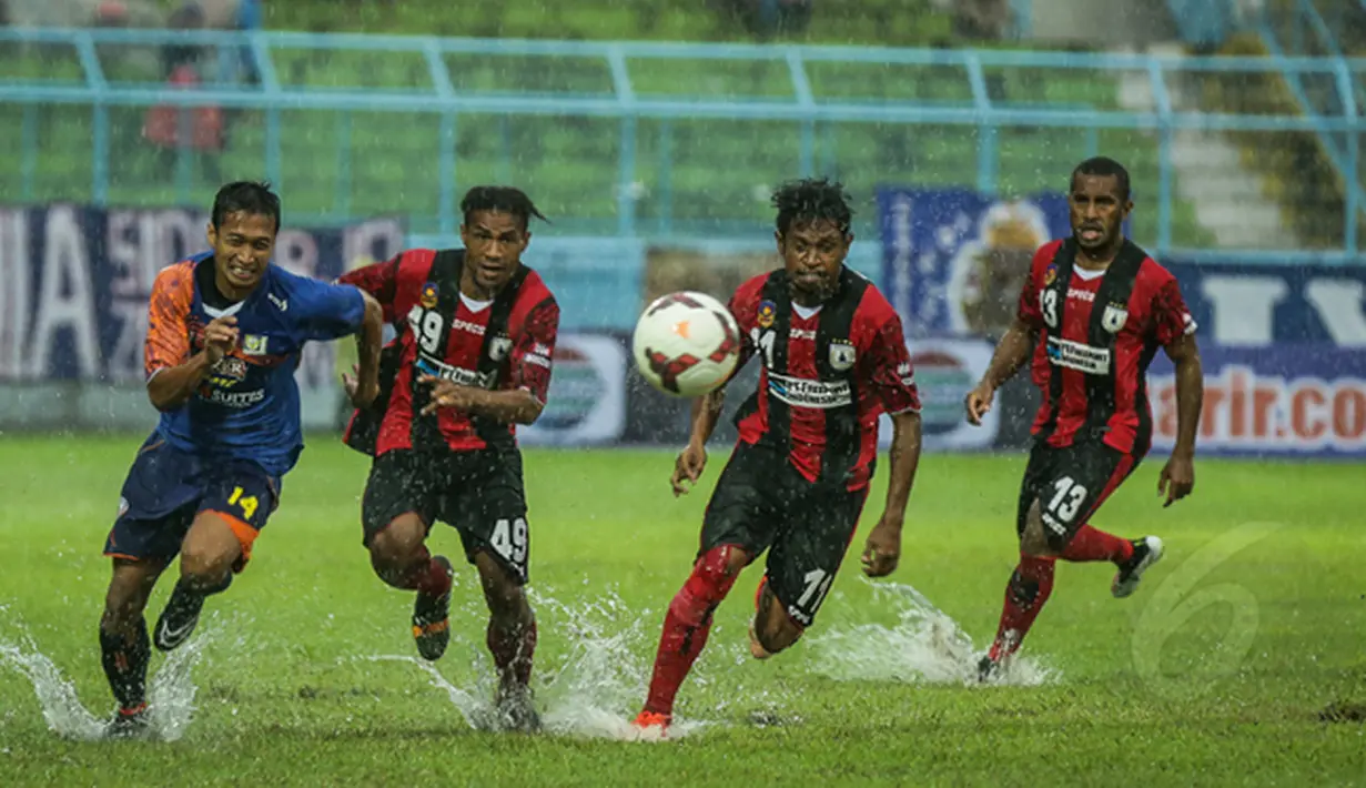 Gelandang Arema Cronus, Arif Suyono berubut bola dengan Tiga Pemain Persipura saat laga SCM Cup 2015 di Stadion Kanjuruhan, Malang, Kamis (22/1/2015) Arema Cronus menang 4-1 atas Persipura (Liputan6.com/Faizal Fanani)