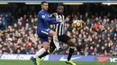 Bek tengah Newcastle Bekel Mbemba berusaha menahan Eden Hazard saat melawan Chelsea di pertandingan Liga Inggris di Stamford Bridge, London (2/12). (AFP Photo/Daniel Leal-Olivas)