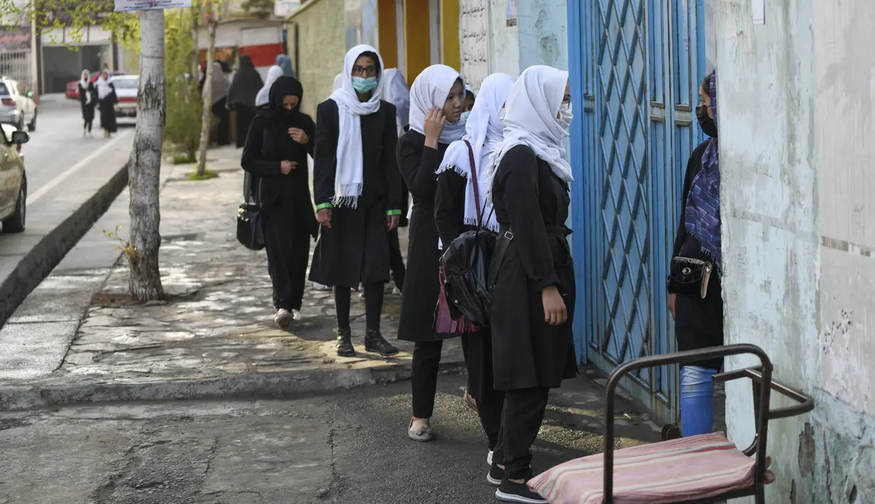 Anak perempuan tiba setelah sekolah mereka dibuka kembali di Kabul, Rabu (23/3/2022). Pembukaan kembali sekolah menengah untuk anak perempuan di seluruh Afghanistan memicu kegembiraan dan ketakutan puluhan ribu siswa yang kehilangan pendidikan sejak Taliban kembali berkuasa. (Ahmad SAHEL ARMAN/AFP)