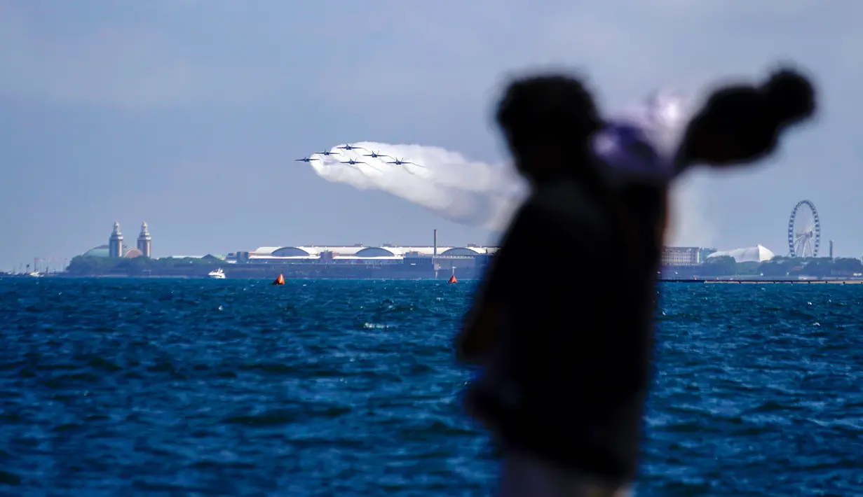 Pengunjung menyaksikan US Navy Blue Angels tampil pada Chicago Air and Water Show di atas Danau Michigan, Chicago, Amerika Serikat, 21 Agustus 2022. Tempat terbaik untuk melihat pertunjukan ini adalah di sepanjang tepi danau dari Fullerton Avenue hingga Oak Street, dengan Pantai North Avenue sebagai titik fokus. (AP Photo/Kiichiro Sato)