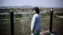 Kafe ini dibangun kurang dari dua kilometer dari perbatasan Korea Utara di Paju, sebelah utara Seoul, Korea Selatan. Tampak dalam foto yang diambil pada tanggal 24 April 2025 menunjukkan pendiri kafe Daonsoop, Lee Oh-sook saat memandang ke arah pegunungan Korea Utara dari tempat usahanya, di Paju, sebelah utara Seoul, Korea Selatan. (ANTHONY WALLACE/AFP)