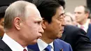 Presiden Rusia Vladimir Putin (kiri) dan Perdana Menteri Jepang Shinzo Abe tiba di tempat pertemuan dialog bisnis Jepang-Rusia di Tokyo, Jepang, Jumat (16/12). (REUTERS / Kim Kyung-Hoon)