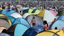 Sejumlah tenda didirikan dekat pengunjung yang berdesakan untuk berburu kerang di pantai kawasan Yokohama, dekat Tokyo, Senin (30/4). Ribuan orang membanjiri pantai selama Golden Week atau periode liburan di Jepang. (AP/Koji Sasahara)