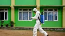 Seorang anggota Badan Penanggulangan Bencana Daerah (BPBD) menyiapkan disinfektan untuk disemprotkan di sebuah Sekolah Menengah Pertama (SMP) dalam rangka program mitigasi pencegahan penyebaran flu burung di Banda Aceh pada Jumat 31 Oktober 2025. Menurut Sukmawati, ini murni langkah pencegahan, bukan karena ada kasus. (Chaideer MAHYUDDIN/AFP)
