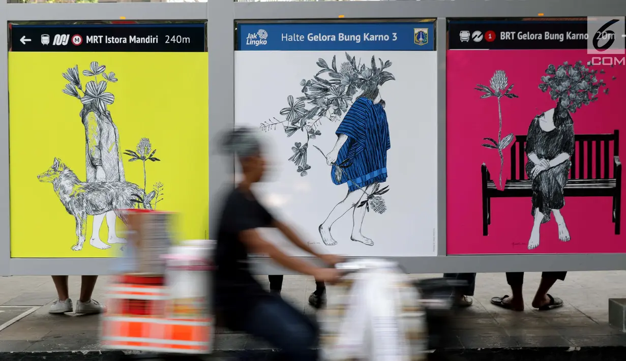 Pedagang minuman keliling melintasi di sisi Halte bus Gelora Bung Karno, Jakarta, Selasa (27/8/2019). Sejumlah karya 10 seniman perempuan Indonesia bertema Perempuan Bicara Seni ditampilkan dalam Jakarta Art Week 2019 yang berlangsung hingga 15 September mendatang. (Liputan6.com/Helmi Fithriansyah)