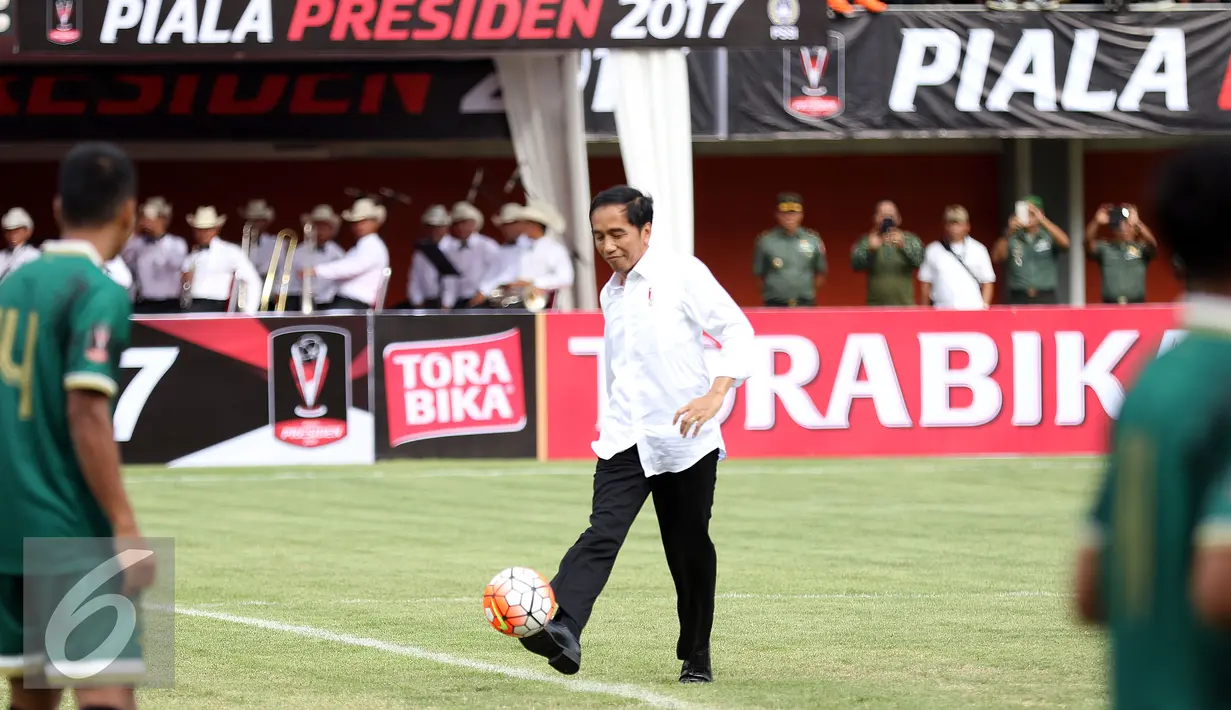 Presiden Joko Widodo menendang bola ke arah pemain PSS saat pembukaan turnamen Piala Presiden 2017 di Stadion Maguwoharjo, Sleman, Sabtu (4/2). 31.000 penonton menyaksikan laga pembuka turnamen Piala Presiden 2017. (Liputan6.com/Helmi Fithriansyah)