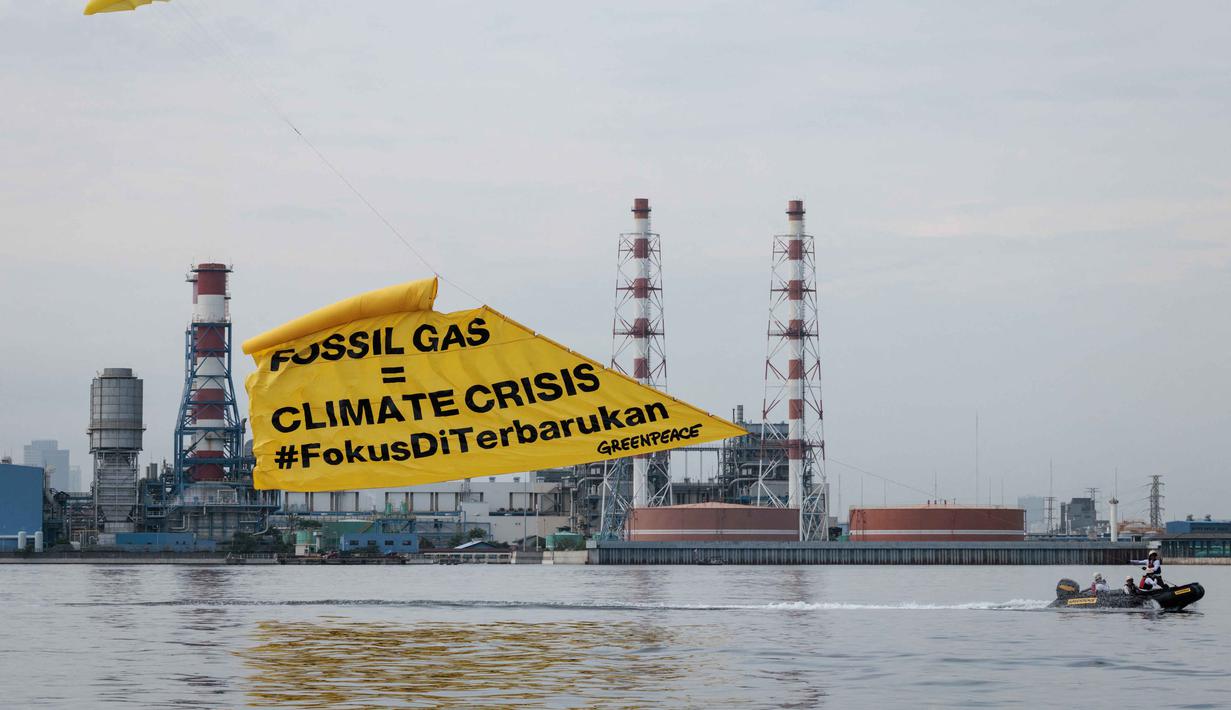Mereka mendesak percepatan investasi energi terbarukan seperti tenaga surya dan angin. Tampak dalam foto, aktivis Greenpeace Indonesia melakukan aksi di kawasan perairan depan Pembangkit Listrik Tenaga Gas Uap (PLTGU) Muara Karang, Jakarta pada Selasa 18 November 2025. (YASUYOSHI CHIBA/AFP)