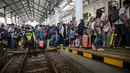 Sementara itu, hingga Selasa (17/3/2026), lebih dari 393 ribu tiket kereta api jarak jauh telah ludes terjual. Tampak dalam foto, para penumpang menaiki kereta di stasiun Gubeng, Surabaya, Jawa Timur, Selasa 17 Maret 2026. (JUNI KRISWANTO/AFP)