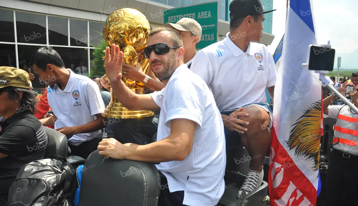 Pemain Arema Cronus, Goran Gancev, dengan trofi juara Torabika Bhayangkara Cup 2016 sesaat setelah tiba di Bandar Udara Abdulrachman Saleh, Malang, Selasa (5/4/2016). (Bola.com/Iwan Setiawan) 