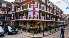 Bendera St George, bendera nasional Inggris, berkibar dari rumah warga menjelang laga final 2024 antara Spanyol vs Inggris di Kirby Estate di Bermondsey, London selatan, Jumat (12/7/2024). (BENJAMIN CREMEL / AFP)