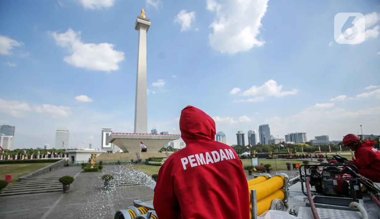 Petugas Pemadam Kebakaran menyemprotkan cairan disinfektan di lingkungan Monas, Jakarta, Rabu (17/6/2020). Penyemprotan dilakukan untuk mencegah penyebaran COVID-19 dalam rangka persiapan pembukaan kembali Monumen Nasional (Monas) pada Sabtu, 20 Juni 2020.  (Liputan6.com/Faizal Fanani)