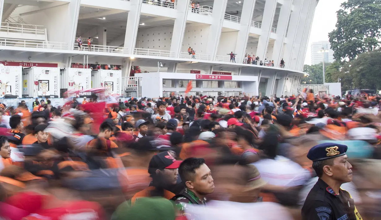 Suporter Persija Jakarta, The Jakmania, yang tidak memiliki tiket berusaha masuk area ring SUGBK dihadang pihak keamanan di Plaza Timur Senayan, Jakarta, Minggu (9/12). Persija melakoni laga penentuan juara melawan Mitra Kukar. (Bola.com/Peksi Cahyo)