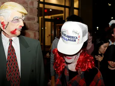 Seorang warga mengenakan topeng sosok Zombie Donald Trump ramaikan perayaan Halloween di Silver Spring, Maryland, AS (29/10). Menjelang pemilihan Presiden AS, Donald Trump banyak dijadikan obyek topeng dalam perayaan Halloween. (Reuters/Gary Cameron)