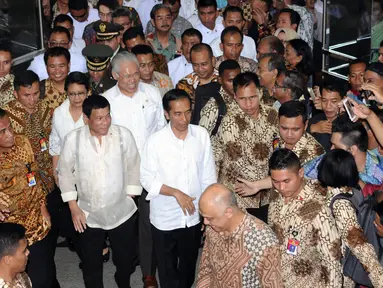 Presiden RI Joko Widodo (kanan) bersama Presiden Republik Filipina ‎Rodrigo Roa Duterte saat tiba di Pasar Blok A Tanah Abang Jakarta, Jumat (9/9). Jokowi mengajak Duterte blusukan di Pasar Tanah Abang. (Liputan6.com/Helmi Fithriansyah)