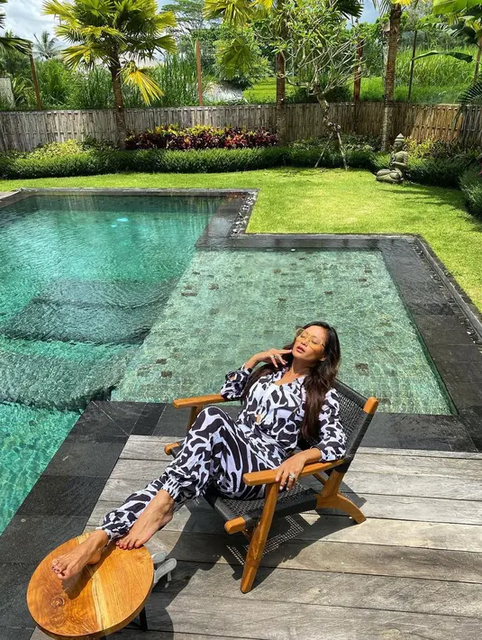 Busana tropis tidak melulu dengan dress. Indah Kalalo membuktikan print jumpsuit juga bisa dijadikan sebagai outfit tropis untuk tampil eksostis.