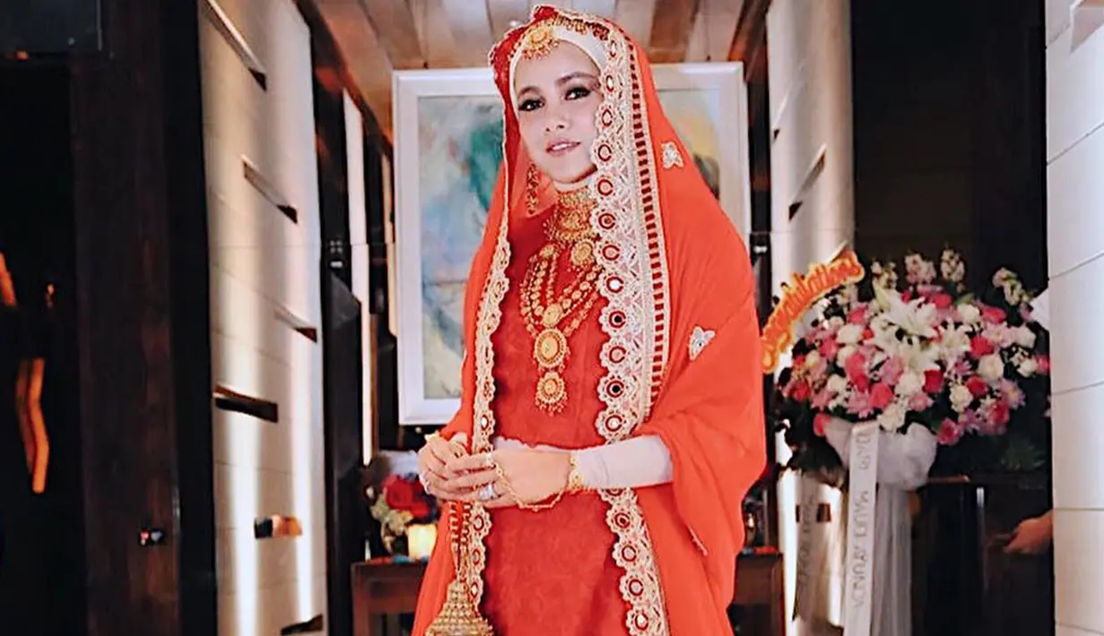 Olla Ramlan tampil anggun dalam pakaian tradisional India, kain sari yang berwarna merah dipadukan dengan hijab berwarna krem dan aksesoris yang berwarna emas. (Liputan6.com/IG/@ollaramlanaufar)