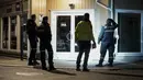 Polisi menyelidiki panah yang tertancap pada dinding setelah serangan di Kongsberg, Norwegia, Rabu (13/10/2021). Polisi masih menginvestigasi apakah insiden ini memang tindakan teror. (Terje Pedersen/NTB via AP)