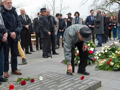 Mantan korban kamp konsentrasi Nazi meletakkan bunga selama upacara peringatan 73 tahun pembebasan di bekas kamp konsentrasi Nazi Mittelbau Dora, Jerman (11/4). (AP Photo / Jens Meyer)