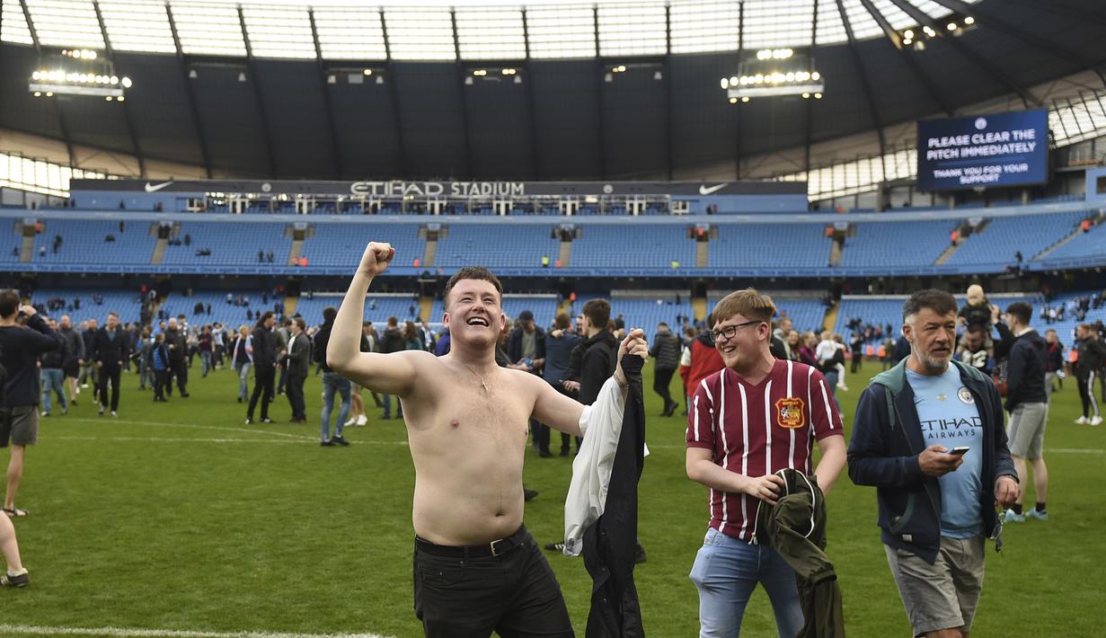 Fans Manchester City menikmati suasana lapangan dengan bertelanjang dada usai laga Manchester City melawan Swansea City pada lanjutan Premier League di Etihad Stadium, Manchester, (22/4/2018). Manchester City menang 5-0. (AFP/Oli Scarff)