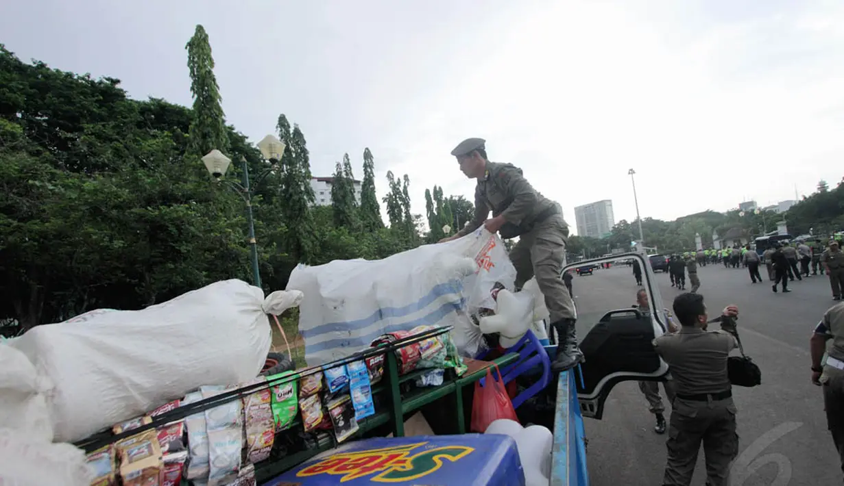 Petugas saat mengangkut barang dagangan PKL ke dalam truk kendaraan operasional dinas, Jakarta, Kamis (4/12/2014). (Liputan6.com/Faizal Fanani)