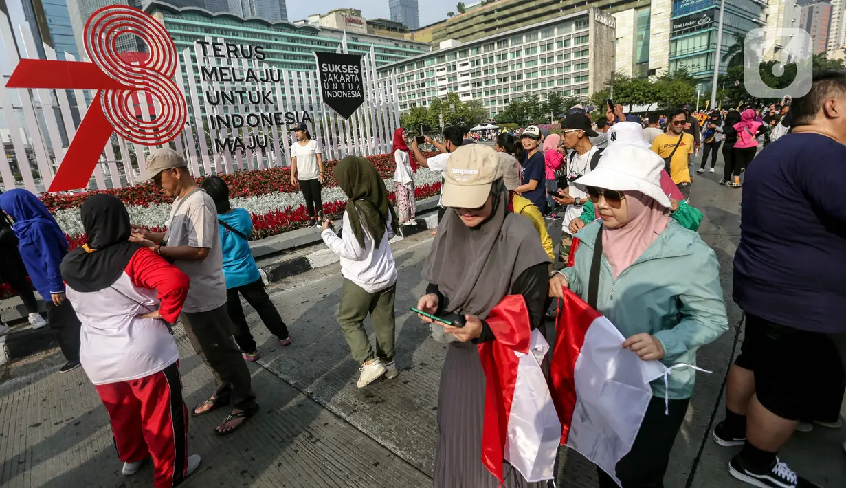 Tak hanya kostum berwarna Merah Putih, sejumlah warga juga tampak membawa bendera Indonesia. (Liputan6.com/Faizal Fanani)