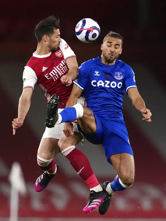 Pemain Arsenal Pablo Mari (kiri) melompat untuk memperebutkan bola dengan pemain Everton Dominic Calvert-Lewin pada pertandingan Liga Inggris di Emirates Stadium, London, Inggris, Jumat (23/4/2021). Arsenal kalah 0-1 dari Everton. (John Walton/Pool via AP)