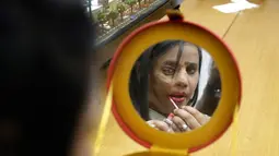 Korban siraman air keras memakai make up sebelum peragaan busana pada malam Hari Perempuan Internasional di Thane, Mumbai, India, Rabu (7/3). Acara ini bagian dari kampanye kesadaran bertajuk 'Stop Acid Sale'. (AP Photo/Rafiq Maqbool)