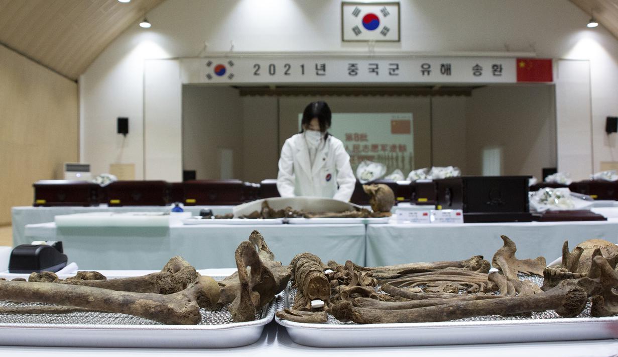 Anggota MND Agency for KIA Recovery and Identification (MAKRI) Korea Selatan menata jenazah tentara China yang tewas dalam Perang Korea di Incheon, Korea Selatan, Rabu (1/9/2021). Korea Selatan memulangkan 109 tentara China yang tewas dalam Perang Korea. (Jeon Heon-kyun/Pool Photo via AP)