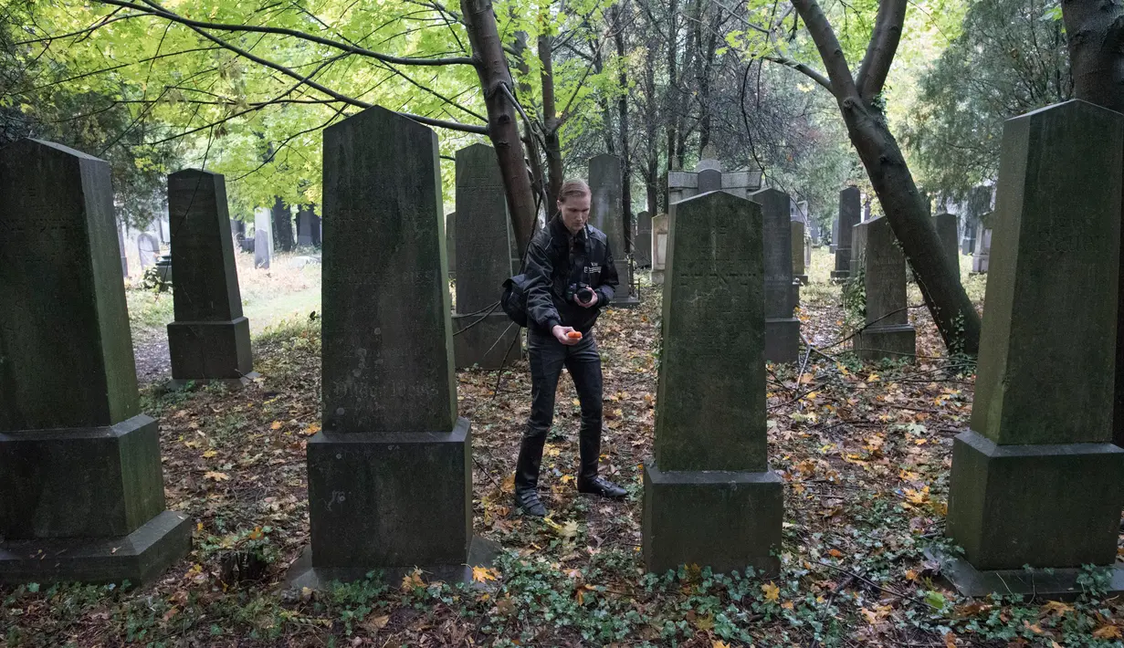 Dominik Creazzi, pemburu hantu dari "Paranormal Investigator" mencari aktivitas gaib di pusat pemakaman tua di Wina, Austria, 20 Oktober 2016. Pemakaman ini disinyalir memiliki aura mistis yang kental dengan aktivitas makhluk halus. (JOE KLAMAR/AFP)