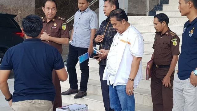 Tersangka korupsi di Riau menunggu mobil tahanan untuk dibawa ke rutan setelah diperiksa jaksa di Kejati Riau.