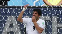 Striker tim nasional Uruguay, Luis Suarez terlihat memegangi mulutnya pada pertandingan penyisihan Piala Dunia Grup D 2014 di Dunas, Brasil, Selasa (24/6/14). (REUTERS/Yves Herman)