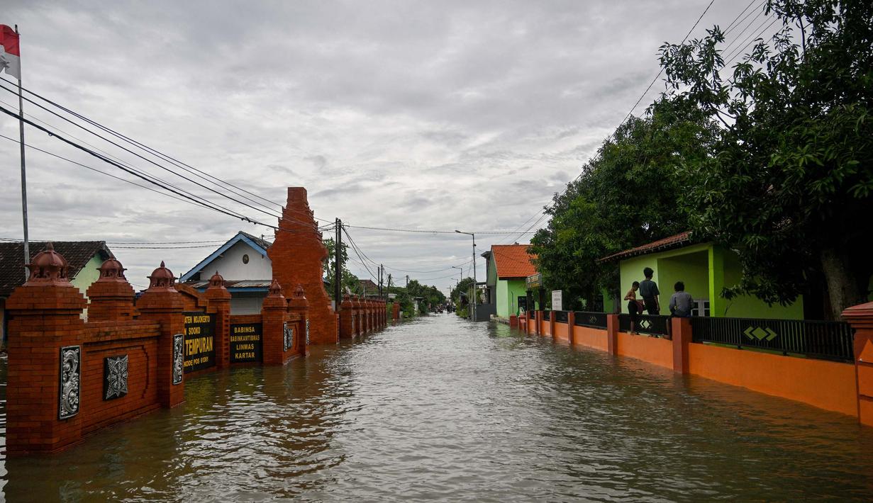 Sebuah jalan yang tergenang air akibat luapan sungai terlihat setelah hujan lebat di desa Tempuran, Mojokerto, Jawa Timur, pada 9 Desember 2024. (Juni KRISWANTO/AFP)
