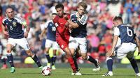 Gelandang Inggris, Dele Alli, berebut bola dengan gelandang Skotlandia, Stuart Armstrong pada kualifikasi Piala Dunia 2018 di Hampden Park, Sabtu (10/6/2017). Skor berakhir imbang 2-2. (AP/Scott Heppell)