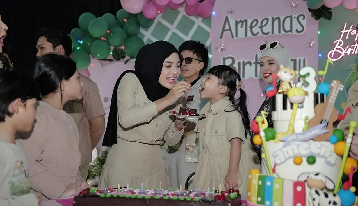 Sebagai bintang utama, Ameena tampil menggemaskan dalam shirt dress warna khaki yang dipadukan dengan kaus kaki putih panjang, mempertegas tema safari yang diusung. [@aurelie.hermansyah].