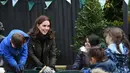 Kate Middleton berbincang dengan anak-anak saat mengunjungi Sekolah Dasar Robin Hood di London, Inggris (29/11). Kedatangan Kate Middleton untuk merayakan sepuluh tahun Kampanye The Royal Horticultural Society (RHS). (AFP Photo/Pool/Eddie Mulholland)