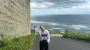 Hyoyeon berada di Bali, saat di pantai ia pun mengenakan bra top biru dipadukan outer kemeja putih dan celana panjang hitam. [@hyoyeon_x_x]