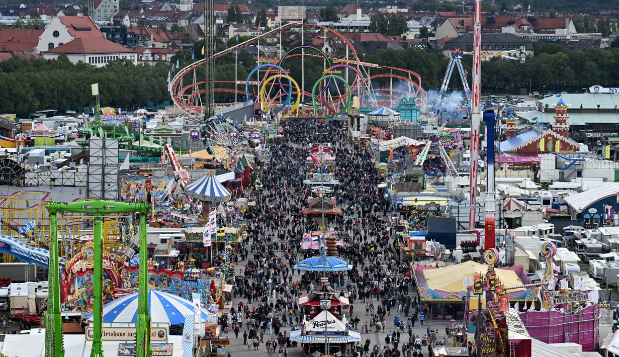 Pemandangan menunjukkan pengunjung berjalan di tempat pekan raya Theresienwiese selama festival bir Oktoberfest di Munich, Jerman selatan (20/9/2022). Festival Bir yang terkenal di dunia ini akan berlangsung hingga 3 Oktober 2022 tanpa batasan akses, setelah dua hari terakhir edisi tahun telah dibatalkan karena pandemi coronavirus. (AFP/Christof Stache)