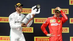 Pebalap Mercedes Lewis Hamilton (kiri) memegang trofi juara disaksikan pebalap Ferrari Charles Leclerc setelah menjuarai F1 GP Prancis 2019 di Sirkuit Paul Ricard, Minggu (23/6/2019). Hamilton tampil dominan dan menjadi juara F1 GP Prancis 2019. (AP Photo/Claude Paris)