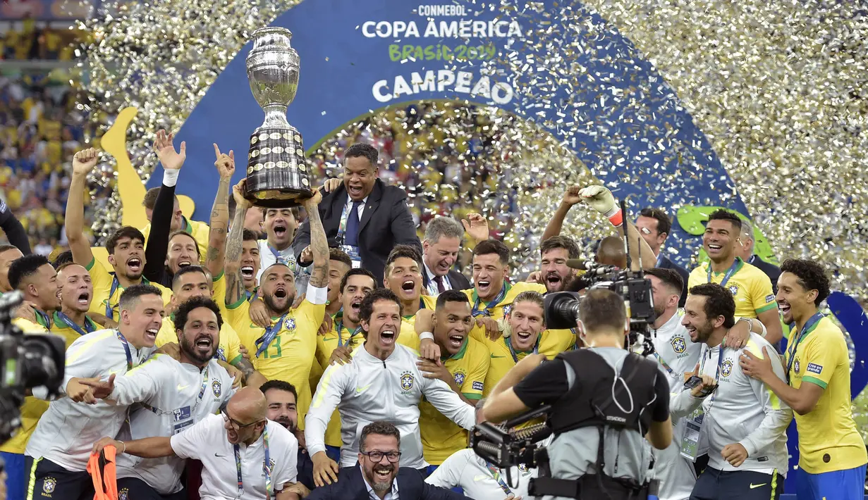 Para pemain dan official Brasil merayakan gelar juara Copa America 2019 setelah mengalahkan Peru pada laga final di Stadion Maracana, Rio de Janeiro, Minggu (7/7). Brasil menang 3-1 atas Peru. (AFP/Carl De Souza)