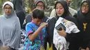 Istri komedian Komeng dan putranya, Bagus, tak kuasa menahan kesedihan saat prosesi pemakaman Cantika Alhayu Aldi di Pemakaman Keluarga Citeureup, Bogor, Minggu (28/8). Putri kembar Komeng itu meninggal di usia 10 tahun. (Liputan6.com/Herman Zakharia)