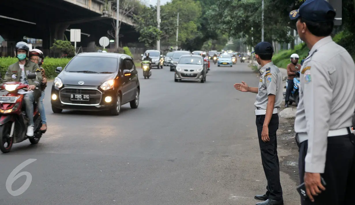 Petugas Dishub mengatur kendaraan yang melintasi Jalan TB Simatupang, Jakarta, Senin (12/12). Dinhubtrans Jaksel menyiagakan petugas di sejumlah titik rawan kemacetan untuk antisipasi penumpukan kendaraan saat arus balik. (Liputan6.com/Yoppy renato)