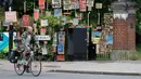 Seorang pria berjalan melewati kumpulan plakat yang dirancang oleh seniman lokal Peter Liversidge untuk mendukung Layanan Kesehatan Nasional (National Health Service/NHS) di London, Inggris, (29/4/2020). (Xinhua/Han Yan)