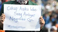 Mahasiswa membentangkan poster saat unjuk rasa di depan Gedung DPR RI, Jakarta, Selasa (1/10/2019). Aksi yang digelar Badan Eksekutif Mahasiswa Seluruh Indonesia itu muncul poster dengan kata-kata lucu yang menyindir disahkannya UU KPK dan menolak RUU KUHP. (merdeka.com/Iqbal S Nugroho)