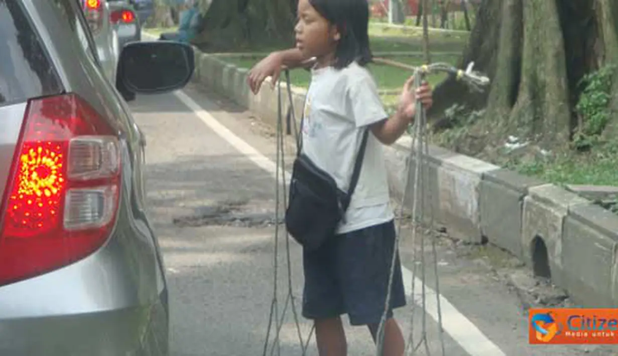 Citizen6, Bandung: Seorang anak sedang menawarkan cobeknya ke pengendara mobil di lampu merah, Jl. Seram, Bandung