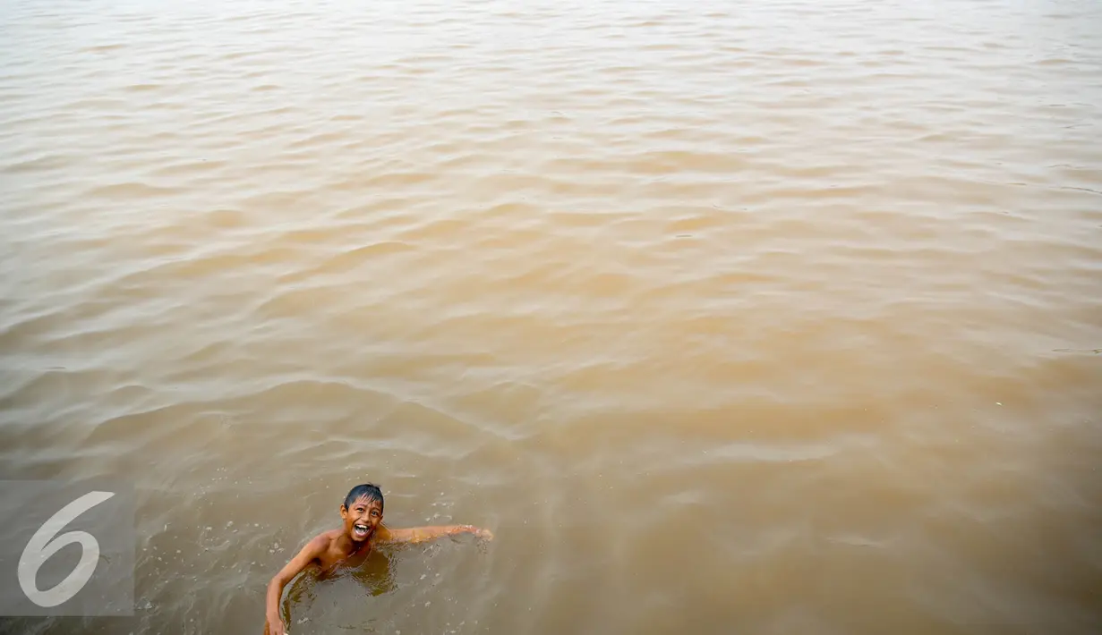 Seorang anak tampak ceria saat berenang di Sungai Kapuas, Pontianak, Kalimantan Barat, Sabtu (22/8/2015). Sungai Kapuas membentang sepanjang 1.143 kilometer. (Liputan6.com/Faizal Fanani)