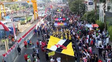 Peserta membentangkan bendera negara anggota ASEAN saat parade ASEAN 50 Tahun di Jakarta, Minggu (27/8). Acara ini merupakan pertunjukan keragaman budaya di Asia Tenggara yang bersatu guna memperingati 50 tahun ASEAN berdiri. (Liputan6.com/Angga Yuniar)