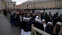 Orang-orang mengantre untuk memasuki Basilika Santo Petrus tempat mendiang Paus Emeritus Benediktus XVI disemayamkan di Vatikan, Senin (2/1/2023). Benediktus XVI, teolog Jerman yang akan dikenang sebagai paus pertama dalam 600 tahun yang mengundurkan diri, telah meninggal pada 31 Desember 2022 di usia 95 tahun. (AP Photo/Alessandra Tarantino)