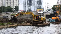 Pekerja dibantu alat berat menyelesaikan pembangunan turap di sepanjang Kali Grogol, Jakarta, Senin (21/11). Pembangunan turap dilakukan untuk mencegah meluapnya air kali saat hujan dan ditargetkan selesai 20 Desember 2016. (Liputan6.com/Gempur M Surya)